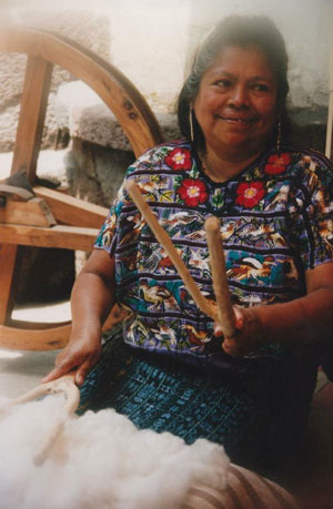 Guatemalan woman preparing raw cotton for weaving