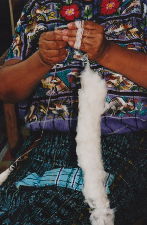 Guatemalan woman making thread from cotton